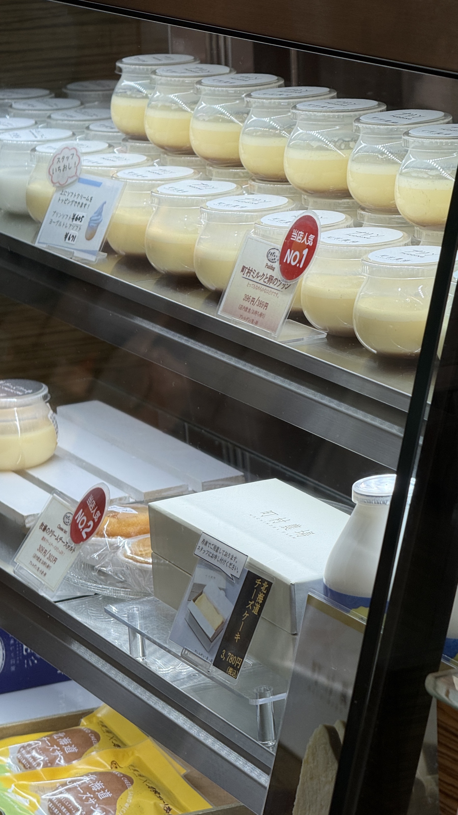 町村ミルク卵のプリンとチーズケーキが並ぶショーケース。瓶入りプリンがずらりと並ぶ