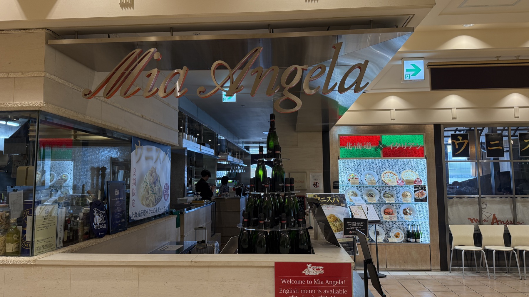 ミア・アンジェラ大丸札幌店の店頭。Mia Angelaのロゴ看板とウニスパののれん、ワインボトルのディスプレイ
