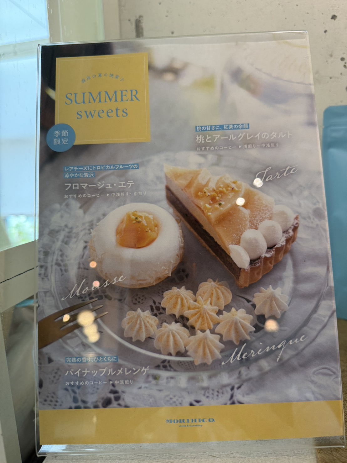 アトリエ森彦の季節限定メニュー表「SUMMER sweets」。フロマージュ・エテ、桃とアールグレイのタルト、パイナップルメレンゲの3種が写真付きで紹介されている